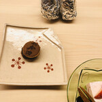 おか田 - 店名が焼印された小さな♡どら焼き。
      奥がおにぎりです✨