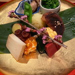 もちづき - 八寸～牡蠣の山椒煮、菜の花の辛子和え、焼き粟麩、じゃが芋のハリハリ、スナップエンドウの塩ゆで、薩摩芋、蛸の柔らか煮、チーズ豆腐の味噌漬け、クリームチーズと干し柿の和え物、昆布巻き、ゴールドラッシュ、赤蒟蒻