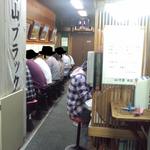 西町大喜 - 壁向かいのカウンターが２列並んでおり、お客さんで一杯。