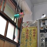 宝屋 - 天井から下がる緑と赤の包装用ビニール