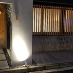 馳走 啐啄一十  - 店舗外観
      落ち着いた雰囲気
      槍鉋で削り出された扉がライトに照らされ陰影を浮かび上がらせています。