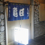 亀田 もつやき店 - 石畳の壁