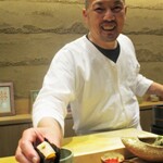 鮨旬美西川 - 烏賊と雲丹の海苔巻き を手渡す大将。（撮影の許可を頂いています。）　　　　2020.05.30