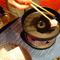 瀬里奈 本店 - 仲居さんがすき焼き鍋に脂を塗る様子です。