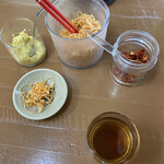 Yoshimaru - お冷と卓上
                        左から生姜、切り盛り大根？、辛いの笑
                        
                        と、麦茶