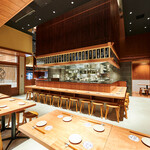 Sakaba Shinatora - 天井が高く開放的なお席となっております。オープンキッチンを囲ったカウンター席が中央にございます。