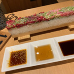 焼肉　戸板商店 - 押し寿司。左半分がユッケ。右半分がネギトロ手前のタレは左からユッケにも付いているユッケだれ 真ん中はゴマ油 右はネギトロだれ