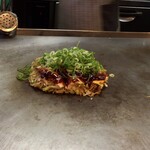 Okonomiyaki Hirano - 女性スタッフさんがネギを載せてくれます・・ネギ増しじゃなくてもたっぷり