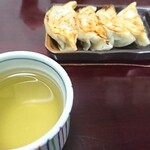 わたりや - 熱いお茶越しのギョウザ(相棒が先に1個食べたところ)。