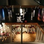 薩摩 牛の蔵 - 店内入口。桜島の昼間と夕方の看板が左右に。