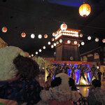 Kawachou - 温泉の次はお食事。
      広小路エリアはお江戸の雰囲気満載だねえ。
      真ん中に祭櫓があるよ。ここで盆踊りを踊ったりするのかな？
      
      ちびつぬ「ここにも仮面ライダーのパネル・・・」