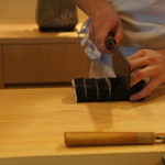 Yoshinosushi - 巻き寿司を寿司切り包丁で切っています。