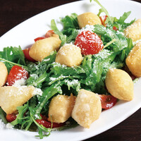 アンジョレッティ (揚げたピッツァ生地・ルッコラ・プチトマトのサラダ仕立て)