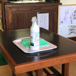 手打 神代そば - お客さんが帰られたらテーブル・椅子をアルコール除菌拭きを実施されています。