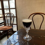 カフェ・グレ - 美しいグラスの「琥珀の女王」。水出しコーヒーの上の生クリームが冷たいうちに、どうぞ。