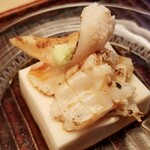緒方 - ①白胡麻豆腐、炭火炙り石影貝(宮城県産)載せ
      酷暑な夏に合わせた冷えた白胡麻豆腐。
      少しコクがある味わいにシルキーな口当たり、主役の石影貝を邪魔せず引き立ています。