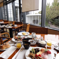 ザ・カフェ - 朝食ブッフェ。オムレツを目の前で焼くなど定番のサービスも。チャペルの庭が見えてキレイです。