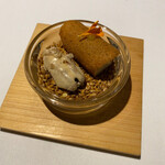 ラ・ヴァガボンド - 胡麻に似た亜麻仁を敷き詰めた上にのるフォアグラとマンゴーを挟んだトンカ豆の焼き菓子、ピーカンナッツ