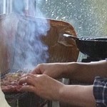 焼き鳥を焼くママさんの手