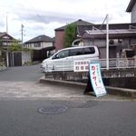 Chiisana Pan Ya Kaiza - 立て看板とお店（車と車庫の向こう）