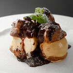 Profiteroles filled with vanilla, caramel and rum ice cream with warm Chocolate sauce