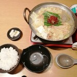 京もつ鍋 亀八 - そろそろ食べ頃なので、ニンニクと一味唐辛子をニラの上へ投入。