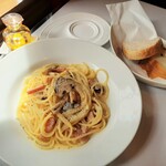イタリア料理オピューム - アルデンテ具合が絶妙！スパゲッティ、キノコとベーコンのクリームソース、奥はクルミ入りカンパーニュとふんわりフォカッチャ