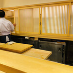 Sushi Ichijirou - 一枚板のカウンターが凛とした店内と大将の背中。