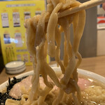 Ramen Sakaba Tengu - 「燕三条ラーメン」「麺大盛り」麺リフト。麺は機械打ち角刃麺、平打ちの極太麺で、やや柔茹でに仕上げられている。食感はうどん Like、小麦の粉感を思わせる噛み応えの麺に、鹹水が使用されているイメージだ。