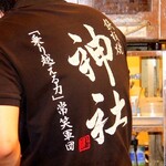 鉄板神社 - スタッフのＴシャツ背中には「乗り越える力」常笑軍団とあります。