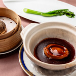 Ezo abalone simmered in earthenware pot with the finest sauce served with steamed buns and Chinese vegetables