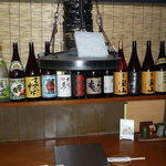 わらおうや - カウンターとカウンターバック棚にこだわり焼酎が並んでいます。