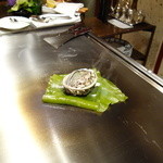 銀座うかい亭 - 鮑に軽く火を入れ、昆布の上で蒸す