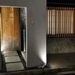 馳走 啐啄一十  - 店舗外観
      落ち着いた雰囲気
      槍鉋で削り出された扉がライトに照らされ陰影を浮かび上がらせています。