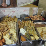 讃岐うどん がもう - 天ぷら、アゲ、たまごなど、トッピングが並ぶ。