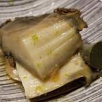 鮨匠 のむら - (13)焚き黒鮑(佐賀県唐津産)
      産卵期は秋～冬(禁漁)、旬は初夏～夏。
      6時間、大根を摺り卸した煮汁100%で炊き込んだ黒鮑は、大変柔らかく、その身がプルプルと震え、旨みも抜群です。