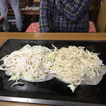 本多 - 生地の上にキャベツと麺　右ソバ、左うどん