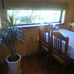 レストランムッシュイソ - 窓から手入れされた庭を眺めることができるテーブル席