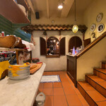 ピッツェリア ブラチェリア チェザリ - カウンター席より店舗奥を見る。左のグリーンのタイルが綺麗。右は二階席階段