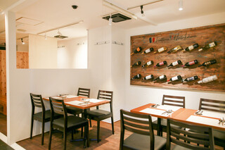 Trattoria Hosokawa - 壁側にワインがオシャレに並んだテーブル席です♪