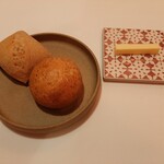 エヴォリュエ - 自家製パンは2種類、グラハムファインを使った丸いパンと四角いライ麦パン、ひんやり冷たく可愛いモザイクタイルの上にはバターが