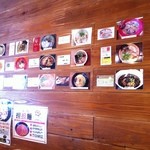 Menya Burakkupiggu - 店内には名店の名刺とラーメンの写真が飾ってありました。