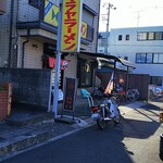 ヒマラヤラーメン - もう建物の影の中に入りつつあって日陰になっている店の外観。