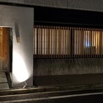 馳走 啐啄一十  - 店舗外観
      落ち着いた雰囲気
      槍鉋で削り出された扉がライトに照らされ陰影を浮かび上がらせています。