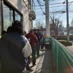 ラーメン二郎 - 建物裏の駐車場へ向かう通路まで行列が連なっていました。