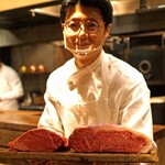 アカ - スタッフの一人が兵庫県産神戸牛のサーロインと黒毛和牛のヒレ肉の２種類の薪焼きステーキ用のお肉を見せてくれます