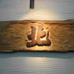 北 - 木彫りのロゴが味があります