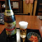 真打 - 瓶ビール中550円税込、小さいキムチが付いてきた。ハートランドの中瓶もあるが100円高くて650円。