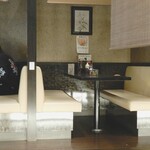 とんかつ 勝 - 内観：私の座った席は掘炬燵形式の座敷ですが、反対側はクリーム色のソファーに黒いテーブルのボックス席です。
