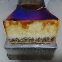 カンテサンス - 断面。三層になっています。上はコンテチーズで作られたベイクドチーズケーキ、真ん中の層はレアチーズ、下は砕いたナッツを入れたタルト状の生地